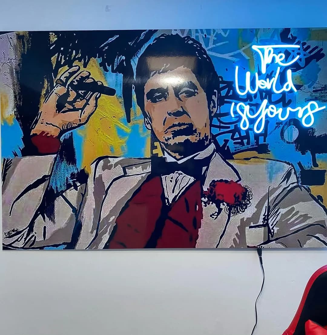 Cuadro de Scarface con neón azul sobre el escritorio de una oficina gamer
