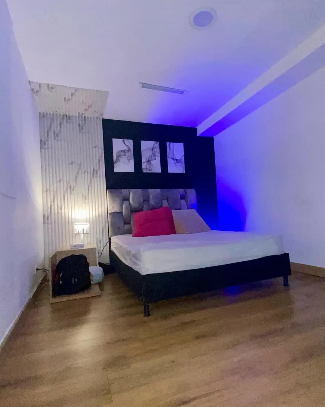 Tríptico de tres láminas sobre la cabecera de una cama con luz azul
